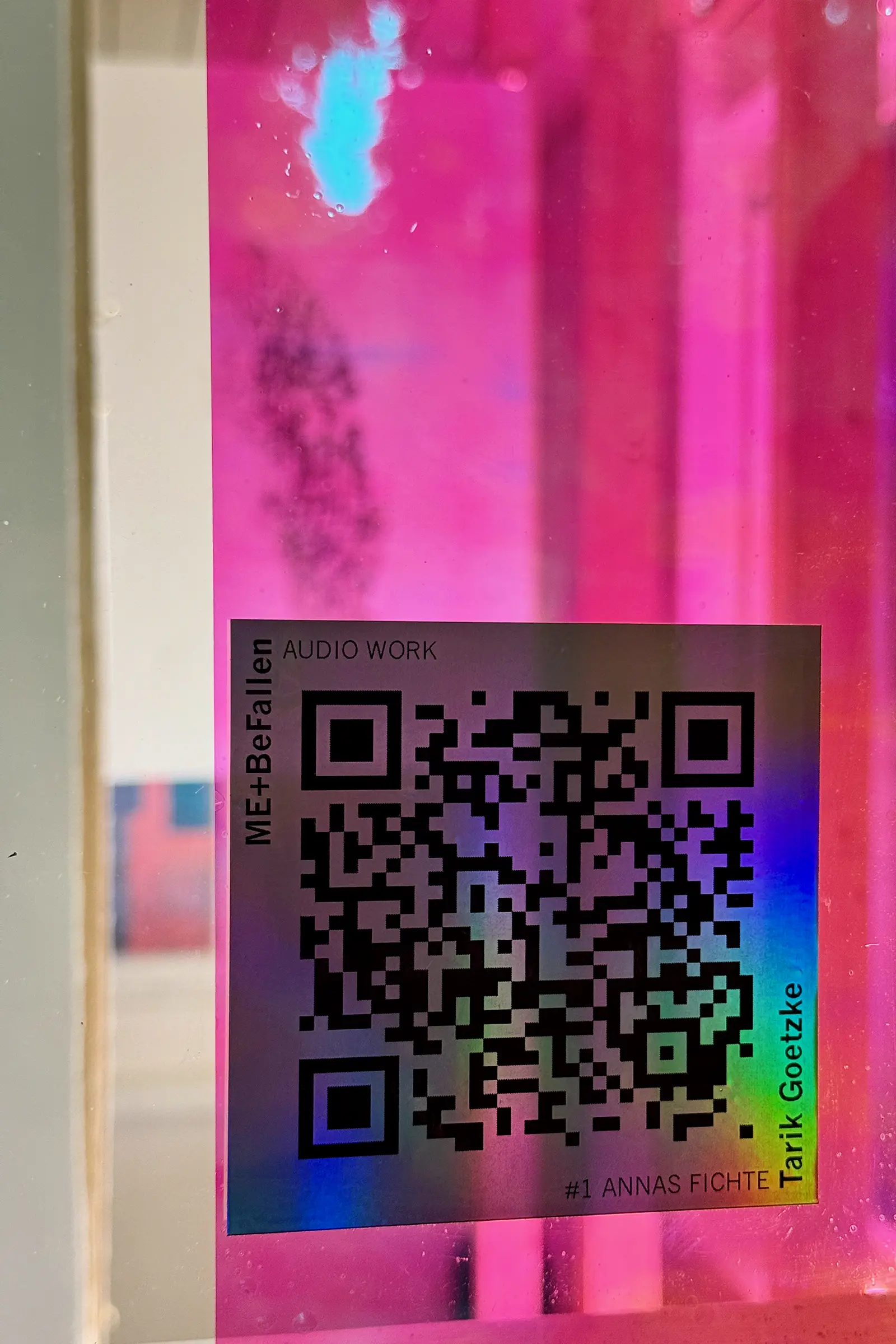 Detail shot of a QR code; black on holographic film in rainbow colors.
