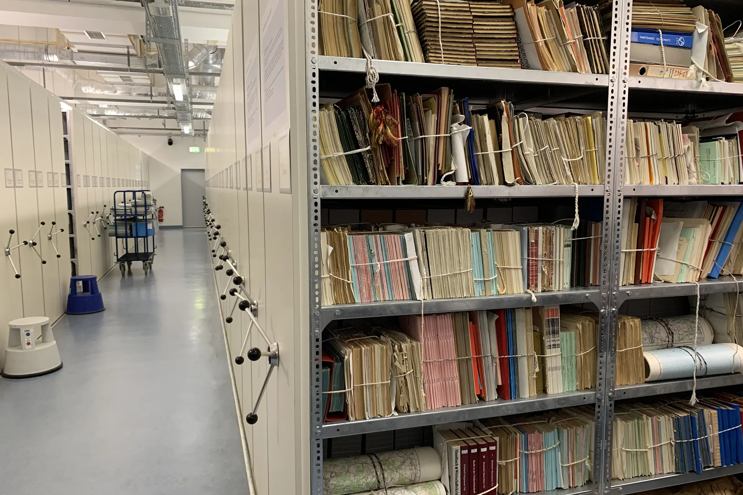 Aisle in the Stasi Records Archive with shelves of files.